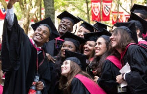Students in cap and gown take a selfie