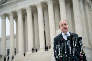 Paul Clement standing in front of the Supreme Court speaking to reporters.