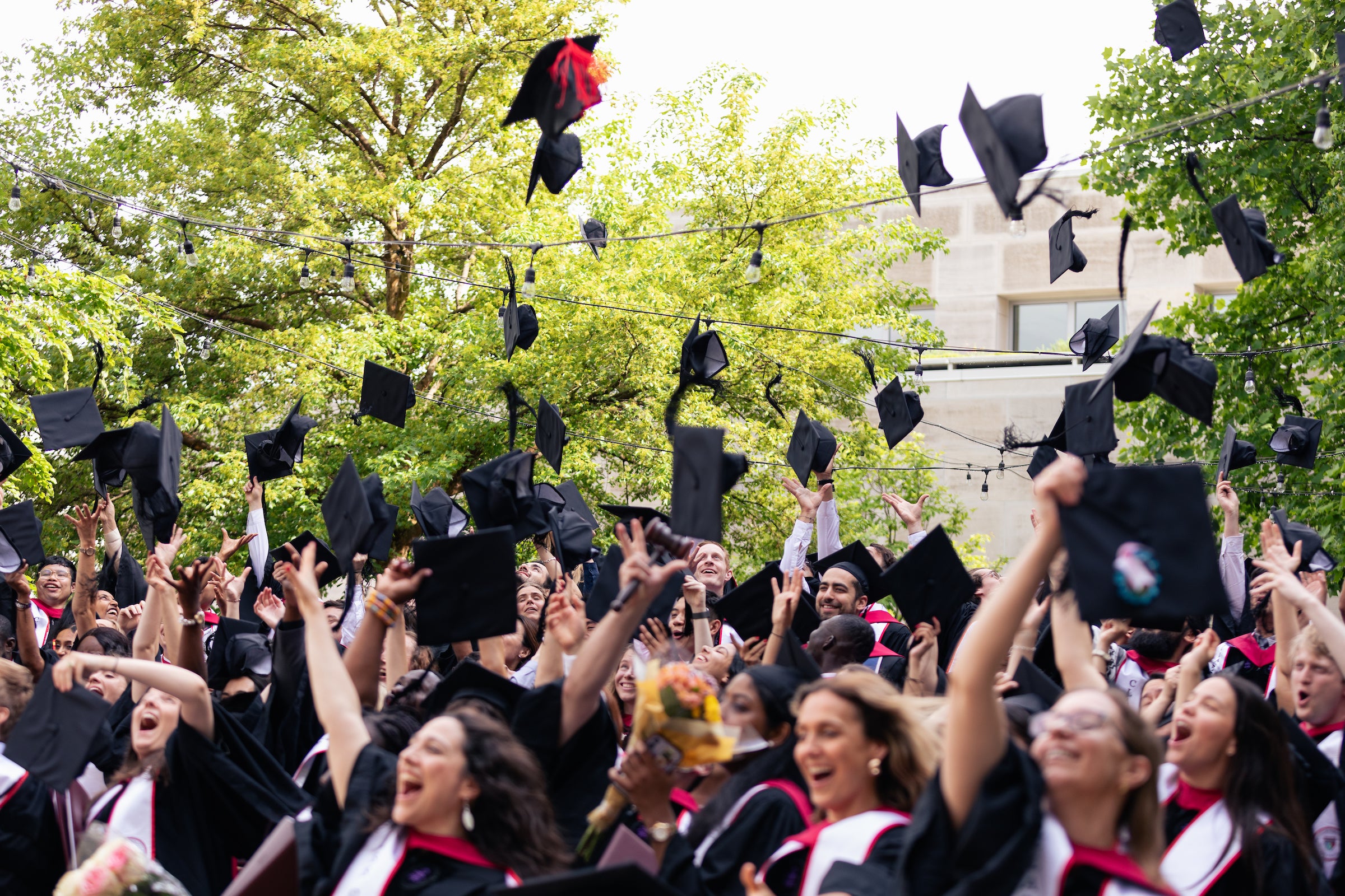 HLS students throwing their caps at Commencement.